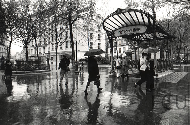 Black and white photo of the metro Place des Abbesses in the rain in the 18th arrondisement, Paris, France
