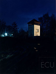 Color photo of a guard tower taken at dusk at the Dachau concentration camp in Germany