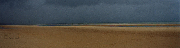 Color photo of Omaha Beach in Normandy France taken on Christmas Day under stormy winter clouds