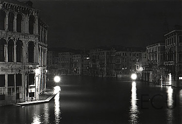 Black and white photo of the Grand Canal at night from the Ponte Rialto in winter in Venice, Italy