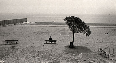 Black and white photo of a woman in winter on Lido Beach along the Adriatic Sea in Venice, Italy
