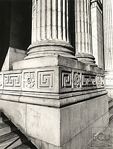 Black and white photo of the stone Beaux Arts architecture of the New York Public Library and its columns on Fifth Avenue