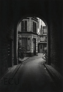 Black and white photo of an arch and courtyard of the rue Sevigne in the Marais district, 4th arrondisement of Paris, France