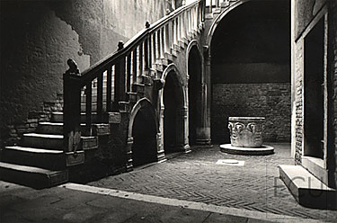 Black and white photo of the arch supported stairs in the Ca' Goldoni, home of the playwright Carlo Goldoni, in Venice, Italy
