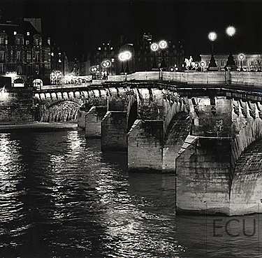 Black and white photo of the oldest Parisian bridge, Pont Neuf, illuminated at night above the Seine, France