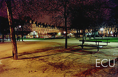 Color photo of the Place des Vosges on the Right Bank in Paris, France at night exemplifying landscape architecture of Henri IV