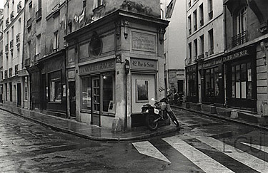 Black and white photo of rue de Seine a left bank gallery street in the rain in Paris, France
