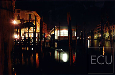 Color photograph taken at night of the vaporetto stop Rialto on the Grand Canal in Venice, Italy
