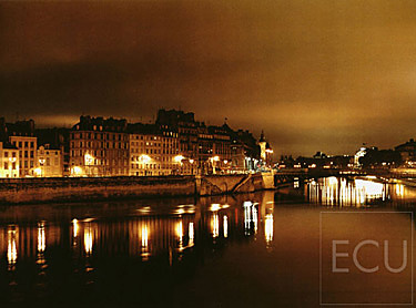 Color photograph taken at night from Pont Louis Philippe over the Seine and the Ile de la Cité