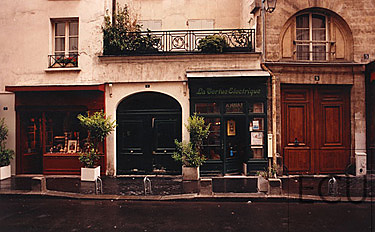 Color photo of traditional Parisian streetscape on Frederick Sautan in 5th arrondisement of Paris featuring French facades with arches and balconies